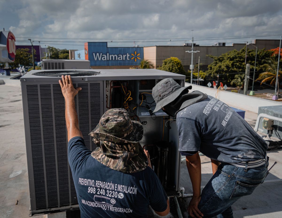 HVAC technicians servicing a unit on a job